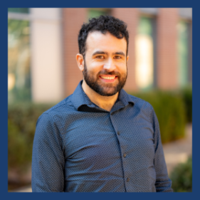 Smiling man with dark hair and beard wearing blue shirt