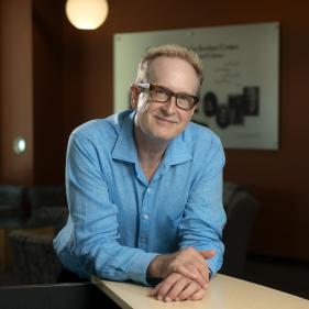 A photo of Dean Tyrus Miller smiling