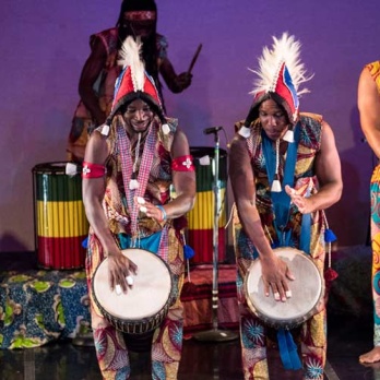 Four African American men playing African drums