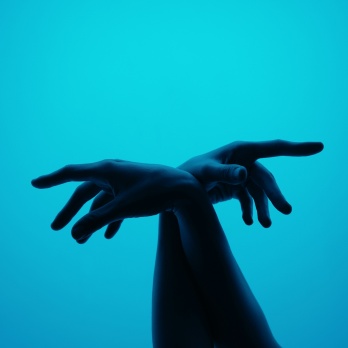 hands crossed in front of blue background