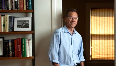 Igler stands next to a bookcase