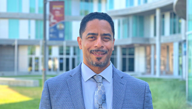 A headshot of Tomas Figueroa in front of Humanities Gateway