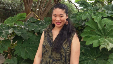 Larissa Fong standing in front of a bunch of greenery.