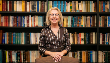 Professor Deanna Shemek standing in front of a large bookcase