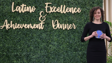 Jeanie Toscano UCI Spanish and Portuguese Ph.D. student wins LEAD Award. She is standing next to the LEAD sign.