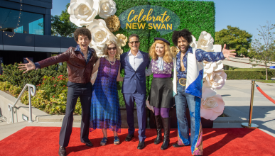 A group of people in costumes smile at the camera.