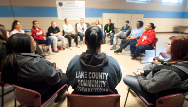 Image of incarcerated women sitting in charis in a circle during a course