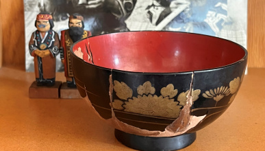 Ancient wooden Bowl in front of 2 wooden images