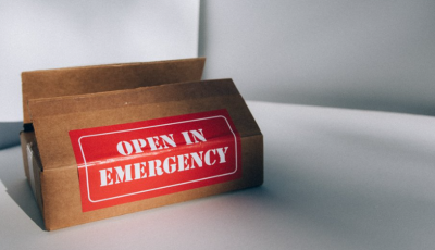brown cardboard box with red open in emergency sticker